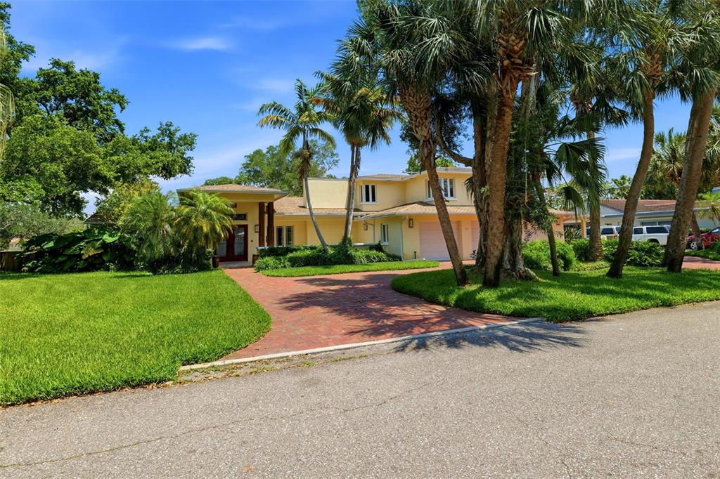 A two-story house with a brick driveway, palm trees, and a three-car garage — 6000 2ND STREET S, ST PETERSBURG, FL