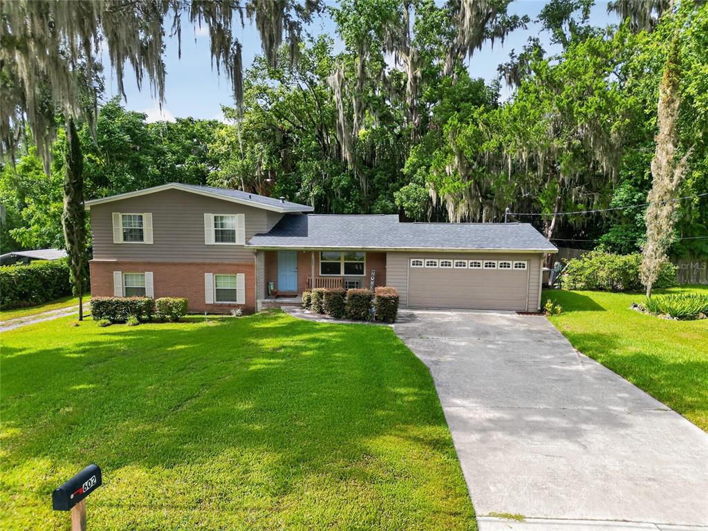 A two-story house with a brick and siding exterior, a garage, and a large lawn — 602 SE 19TH STREET, OCALA, FL