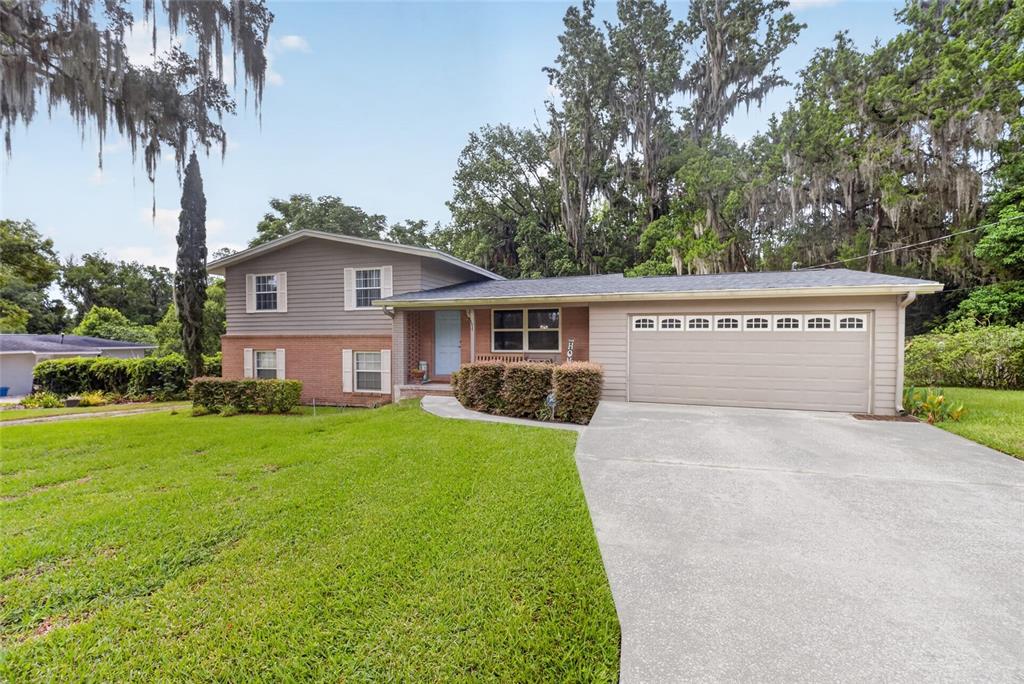 A two-story house with a brick and siding exterior, a garage, and a front lawn — 602 SE 19TH STREET, OCALA, FL