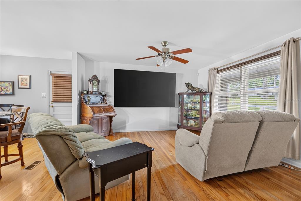 A living room features hardwood floors, a large wall-mounted television, and two reclining sofas — 602 SE 19TH STREET, OCALA, FL