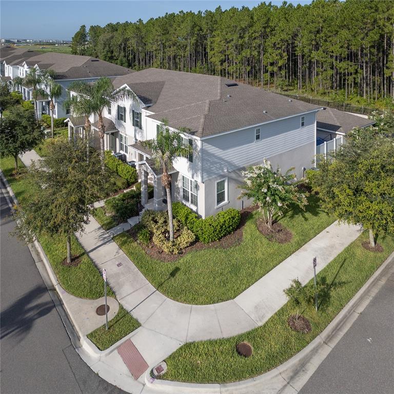 An aerial view shows a two-story townhouse with a corner lot and surrounding landscaping — 6208 ARALIA IVY LANE, WINTER GARDEN, FL