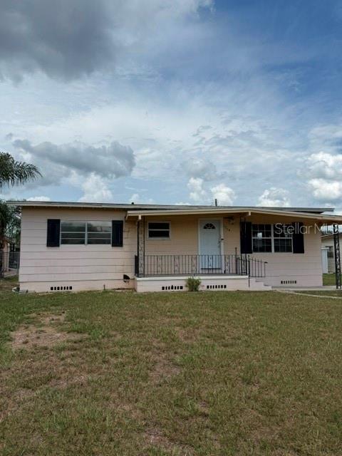 A single-story house with light-colored siding, a front porch, and a grassy yard — 1730 HUNTINGTON STREET, LAKELAND, FL