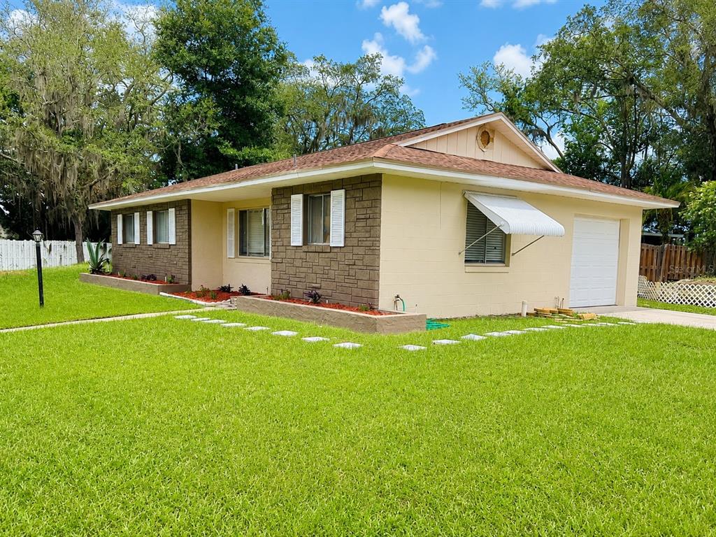 A kitchen and dining area with white cabinets, light wood-look flooring, and a breakfast bar — 4410 WATCH HILL ROAD, ORLANDO, FL
