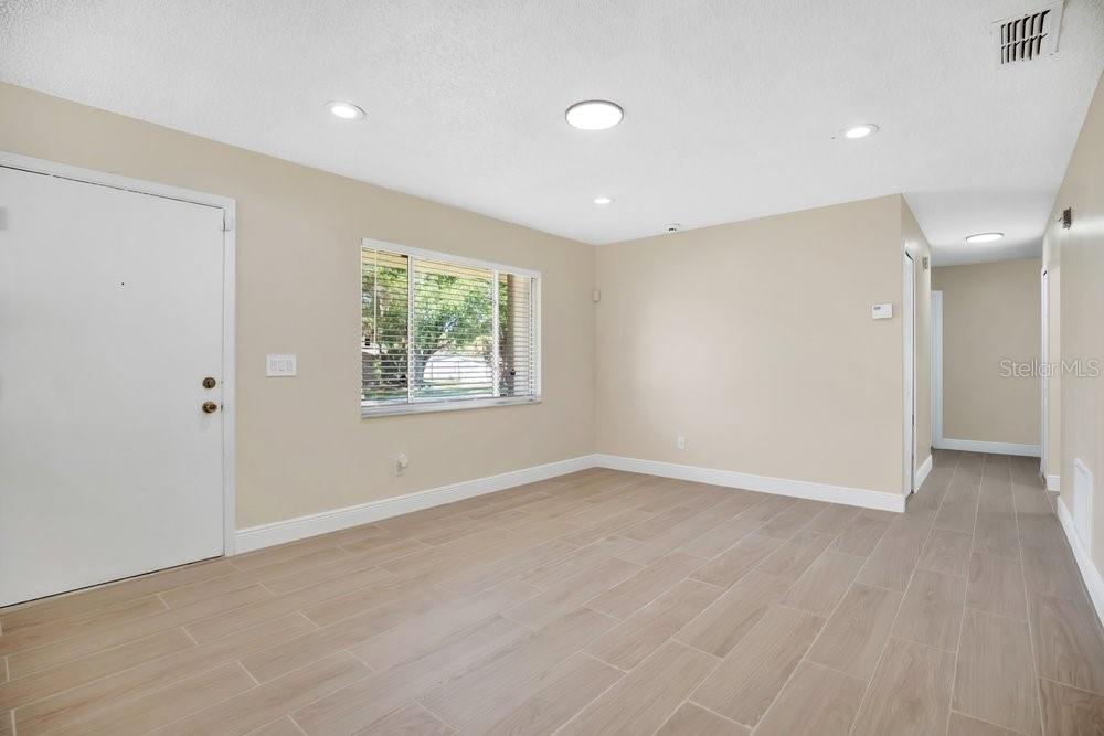 An empty room with light-colored walls, tile flooring, a window with blinds, and recessed lighting — 4410 WATCH HILL ROAD, ORLANDO, FL