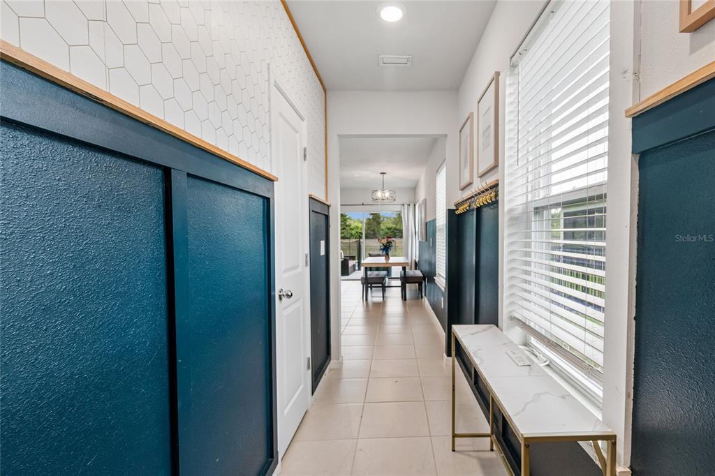 A kitchen with white cabinets, stainless steel appliances, and a blue-paneled entryway — 9047 ROYAL RIVER CIRCLE, PARRISH, FL
