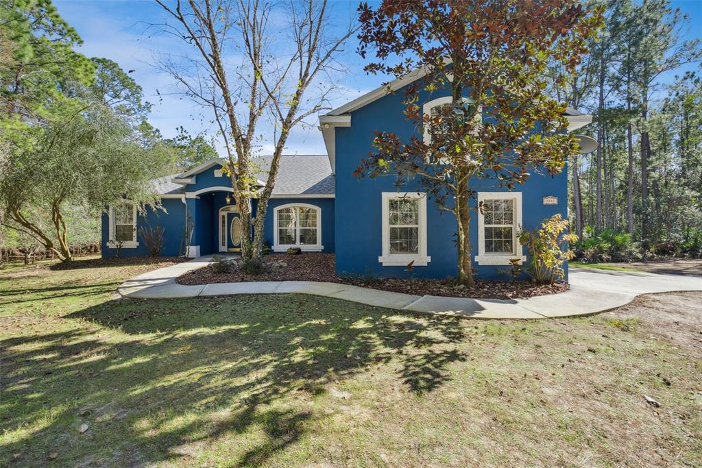 An aerial view shows a house with a swimming pool surrounded by dense forest — 3441 HICKORY CREEK ROAD, DELTONA, FL
