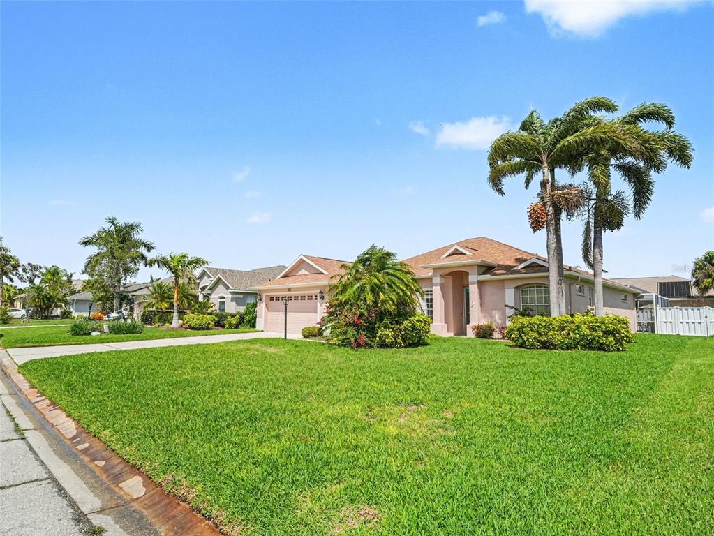 A single-story peach-colored house with a two-car garage and palm trees in the front yard — 535 PLANTERS MANOR WAY, BRADENTON, FL