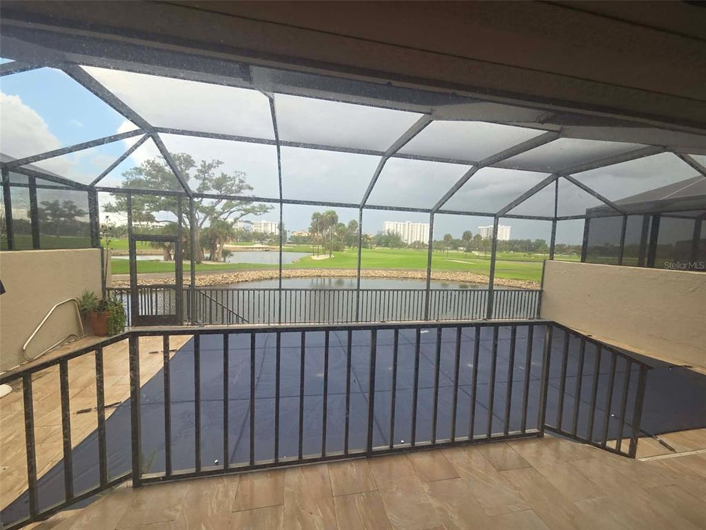 A screened-in patio overlooks a golf course and a small pond — 2321 HARBOUR OAKS DRIVE, LONGBOAT KEY, FL