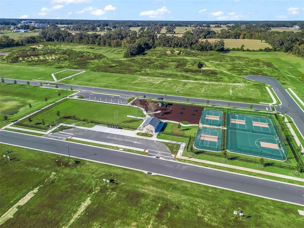 An aerial view shows a community park with a playground, tennis courts, and parking area — NE 125TH LOOP, PHASE 4, OXFORD, FL