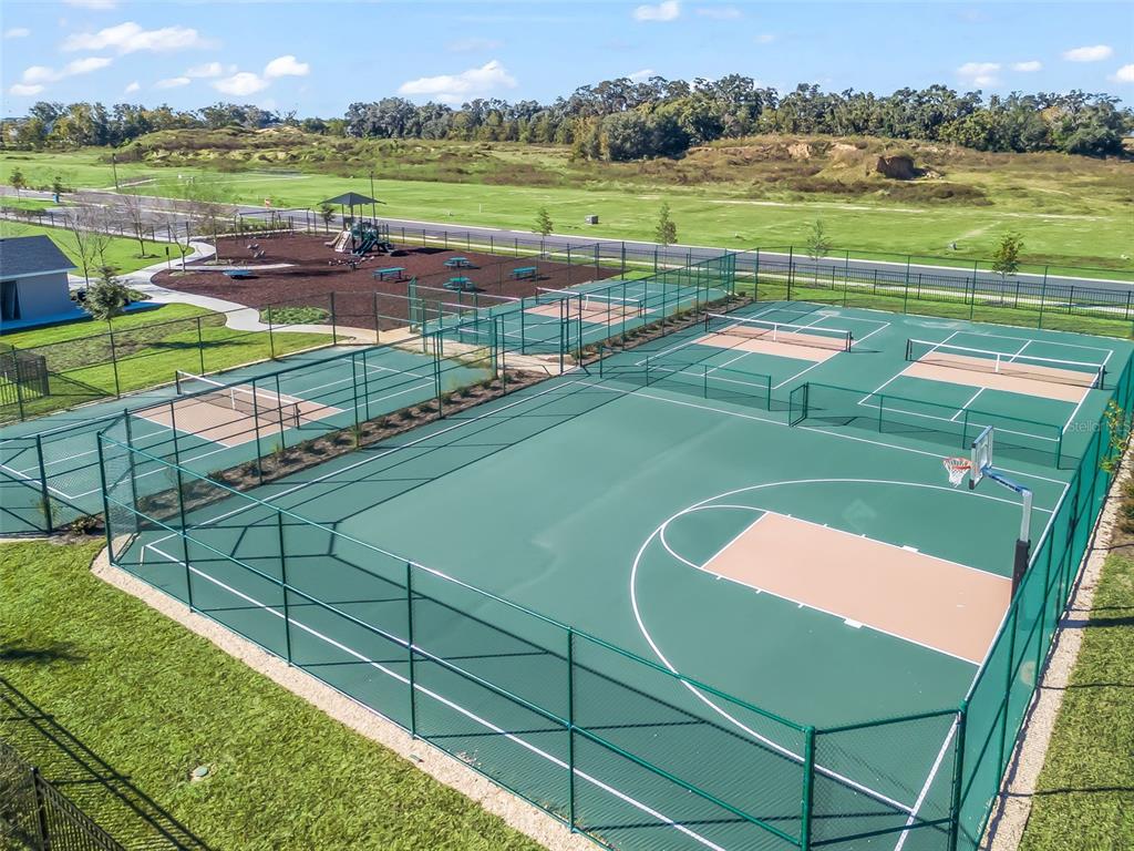 An aerial view of a fenced outdoor sports complex featuring a basketball court and tennis courts — NE 125TH LOOP, PHASE 4, OXFORD, FL