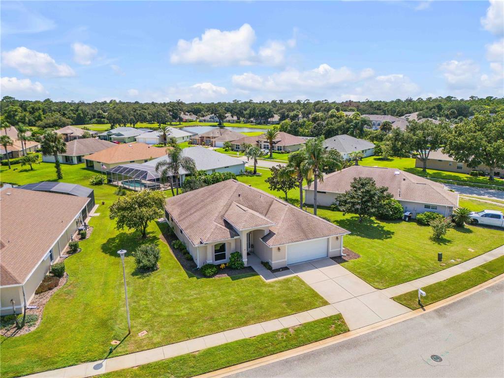 An aerial view of a suburban single-story house with a tan roof and attached garage — 1858 TURNBULL LAKES DRIVE, NEW SMYRNA BEACH, FL