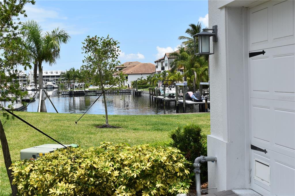 A view of a canal with boat docks and residential buildings from a garage exterior — 3027 BERMUDA SLOOP CIRCLE, RUSKIN, FL