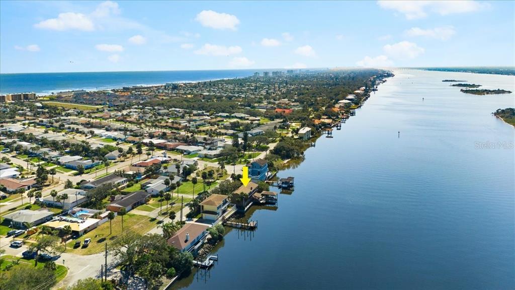An aerial view shows a waterfront house with a yellow arrow pointing to its roof — 2306 JOHN ANDERSON DRIVE, ORMOND BEACH, FL