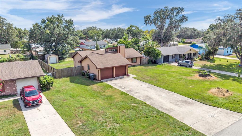 An aerial view of two suburban houses with driveways, lawns, and mature trees — 2236 COUNTRY LOOP N, LAKELAND, FL