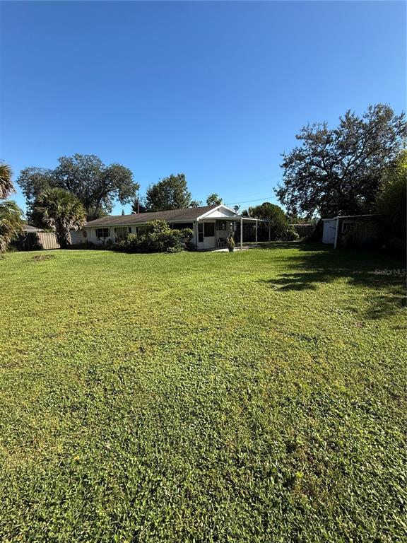 A single-story house with a covered porch sits on a large, grassy lot — 1985 ALADDIN COURT, ST CLOUD, FL
