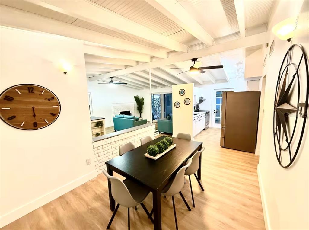 A dining area with a dark table and chairs opens into a living room and kitchen — 2446 SHELLEY STREET, CLEARWATER, FL