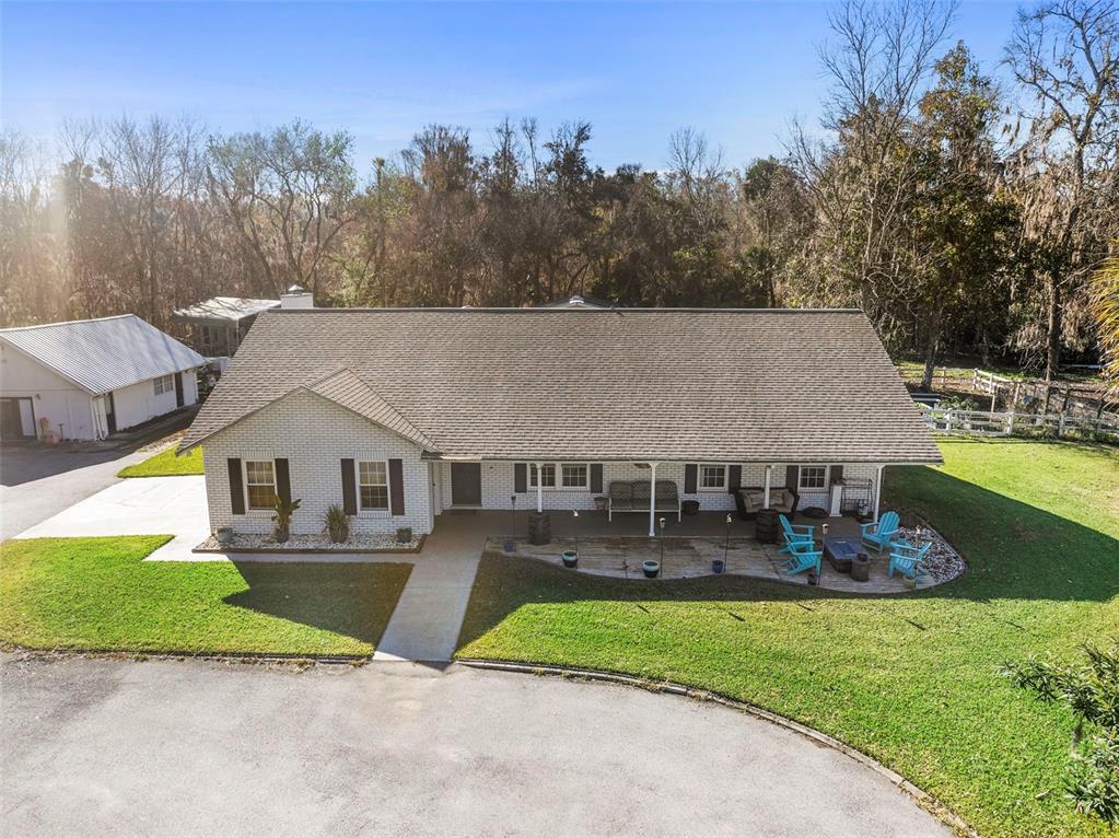 An aerial view shows a single-story brick house with a large roof and front patio — 3080 RAGIS ROAD, EDGEWATER, FL