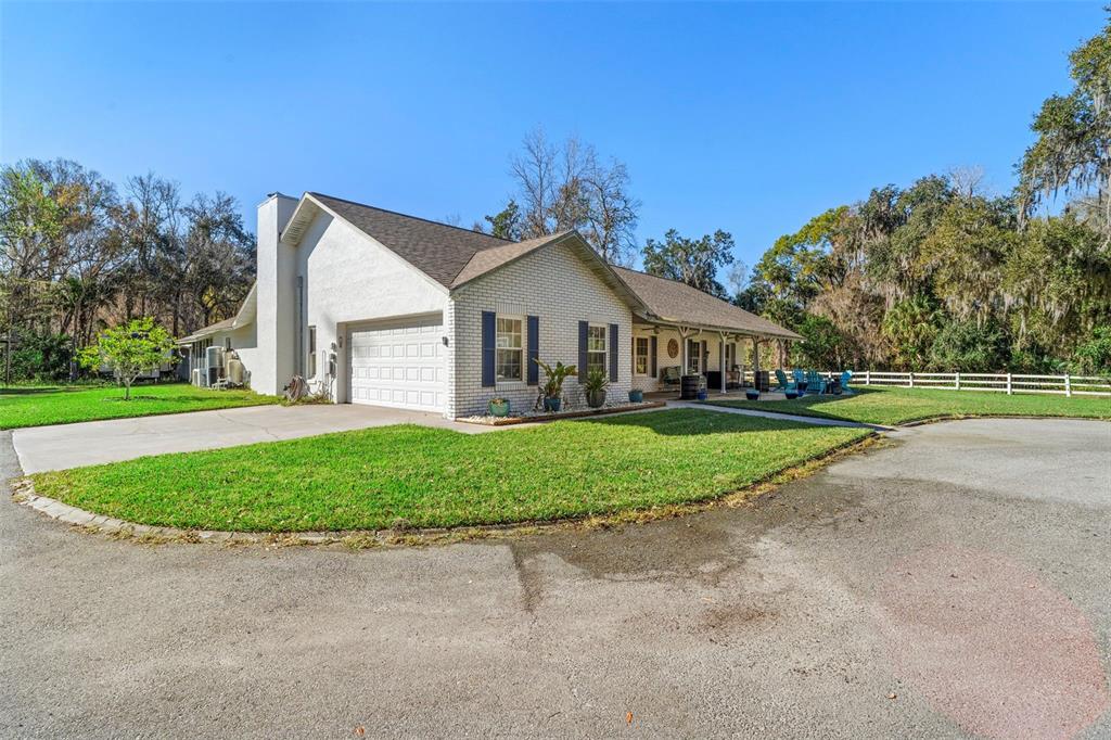 A single-story white brick house with a garage and a covered front porch — 3080 RAGIS ROAD, EDGEWATER, FL
