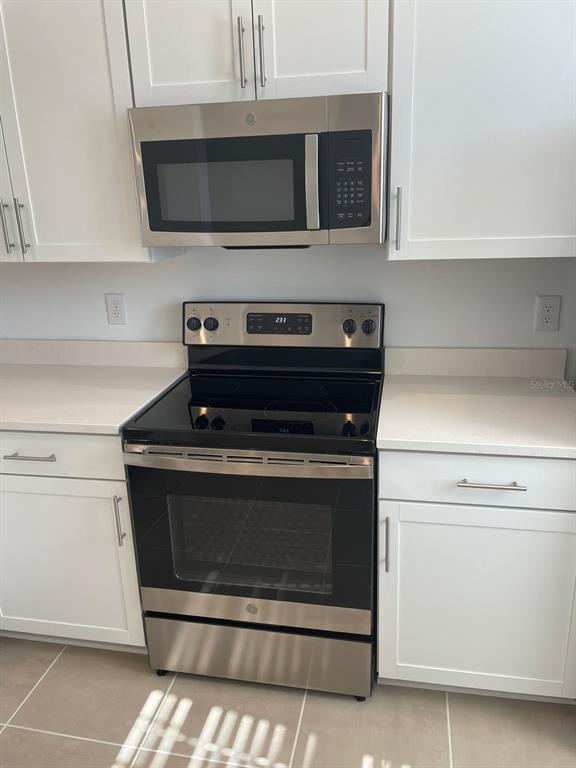 A kitchen features white cabinets, stainless steel appliances, and light-colored countertops — 6330 FAIRMONT LANE, PALMETTO, FL