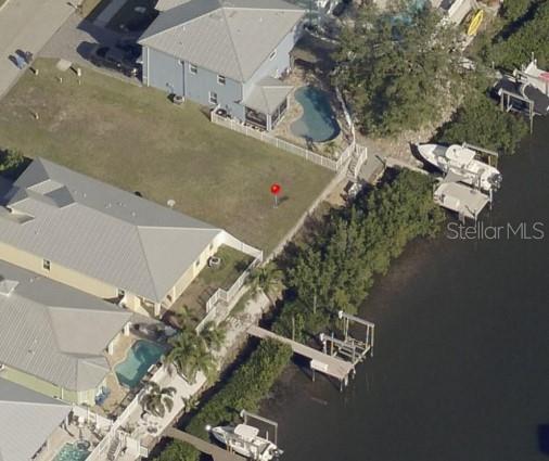 An aerial view shows a waterfront residential lot with a red marker and private dock — 421 BAHAMA GRANDE BOULEVARD, APOLLO BEACH, FL