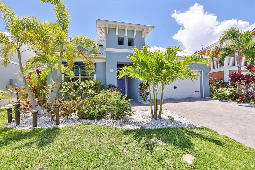 A blue house with a white garage door, palm trees, and a paved driveway — 421 BAHAMA GRANDE BOULEVARD, APOLLO BEACH, FL