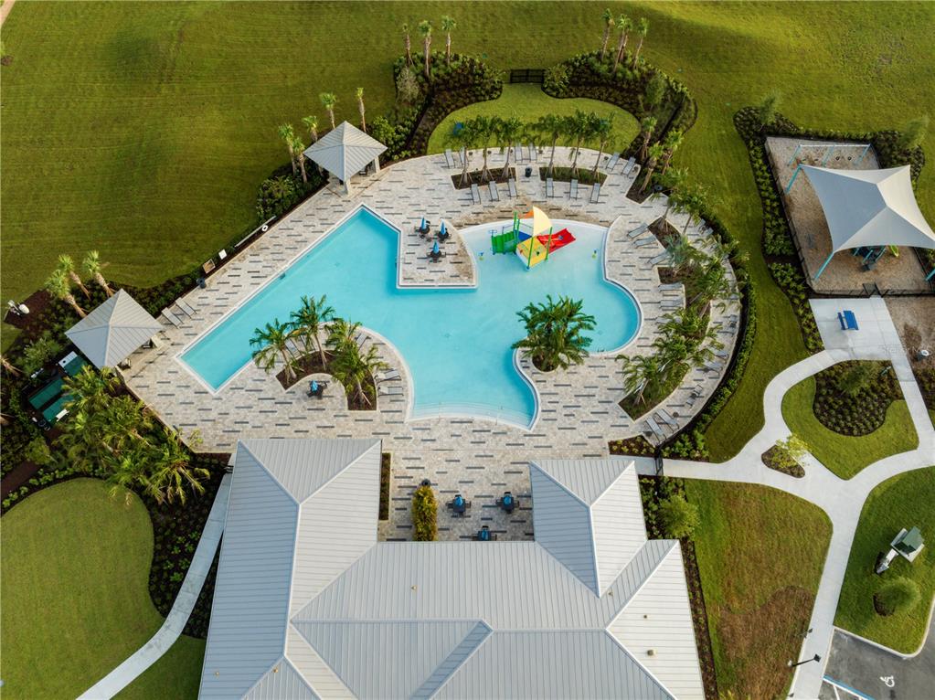 An aerial view shows a swimming pool with a splash pad and a nearby playground — 7272 ROLLING LEAF ROAD, GROVELAND, FL