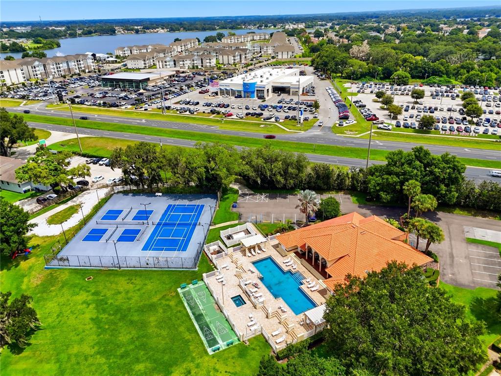 An aerial view shows a tennis court, a swimming pool, and a clubhouse with parking — 701 MAGNOLIA PLACE, WINTER HAVEN, FL