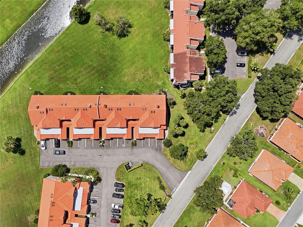 An aerial view shows several residential buildings with red tile roofs and surrounding parking lots — 701 MAGNOLIA PLACE, WINTER HAVEN, FL