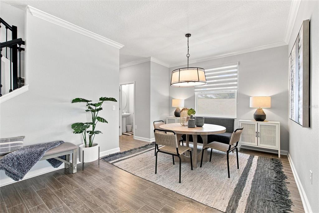 A dining area features a round table, chairs, a bench, and a light-colored area rug — 8871 BACKSPIN LANE, DAVENPORT, FL