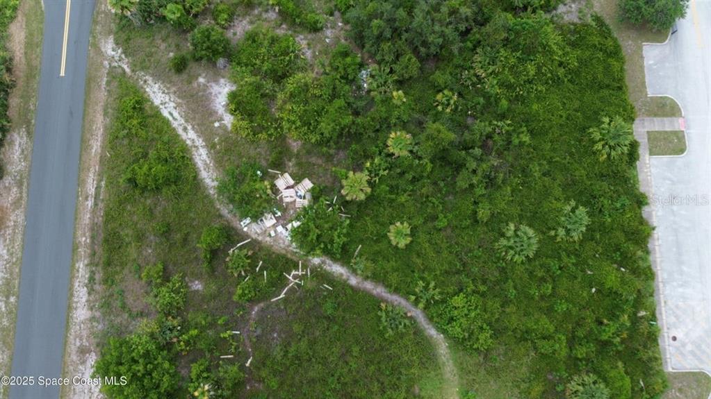 An aerial view shows a vacant, overgrown lot situated between two paved roads — 3765 KINGS HIGHWAY, COCOA, FL