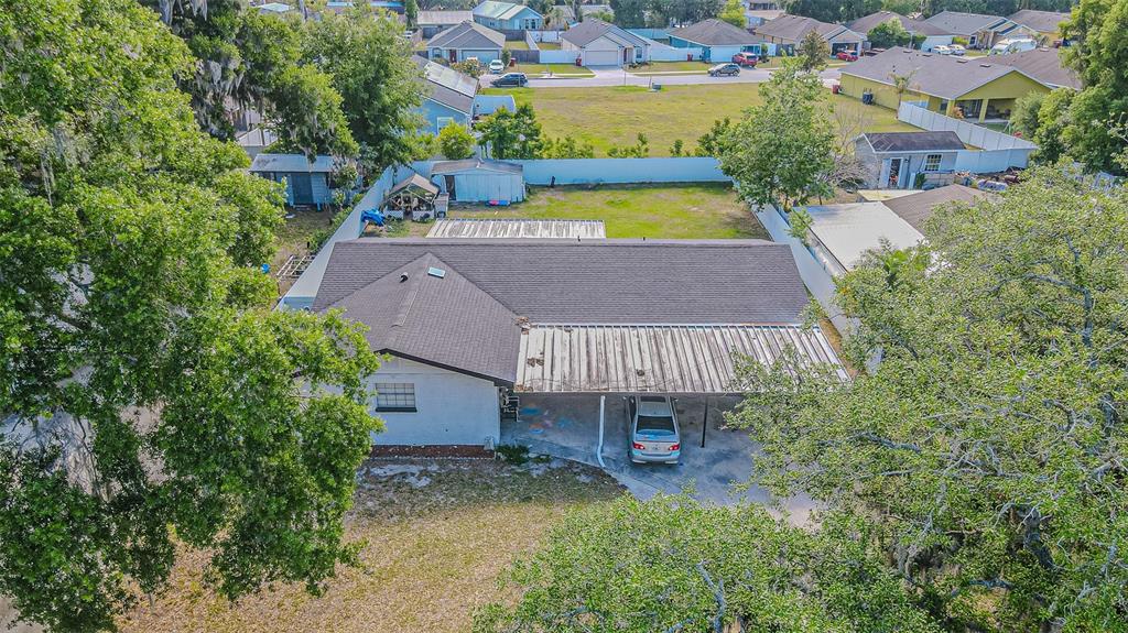 An aerial view shows a single-story house with a metal carport and a large backyard — 402 EUNICE DRIVE, PLANT CITY, FL