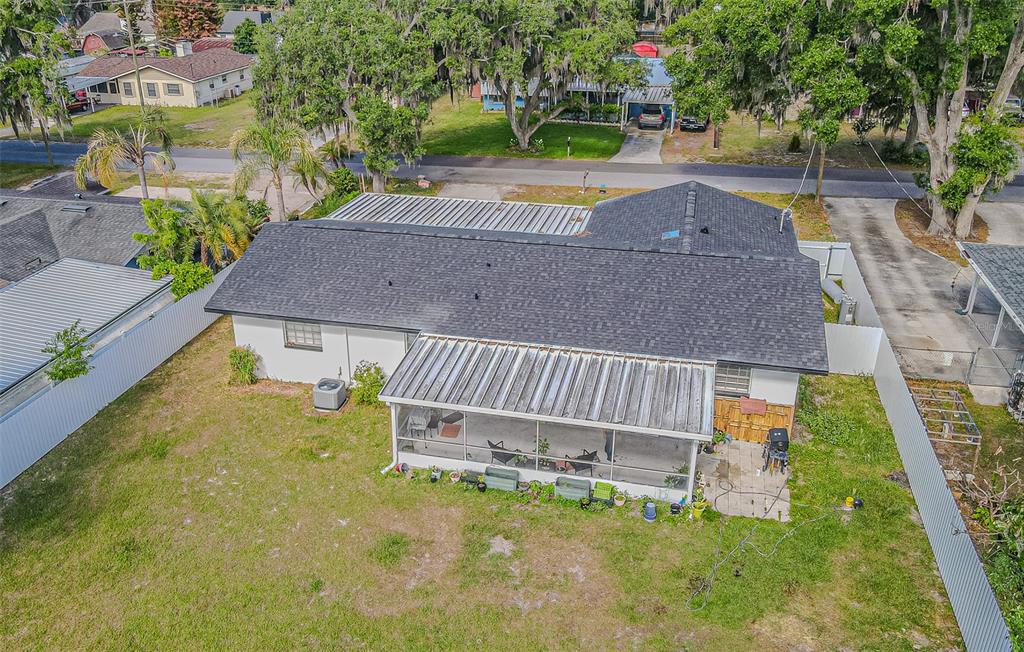 An aerial view shows a house with a shingled roof, a screened-in patio, and backyard — 402 EUNICE DRIVE, PLANT CITY, FL