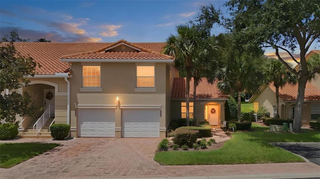 A two-story house with a terracotta tile roof, a two-car garage, and a paved driveway — 5418 COMPASS POINT, OXFORD, FL