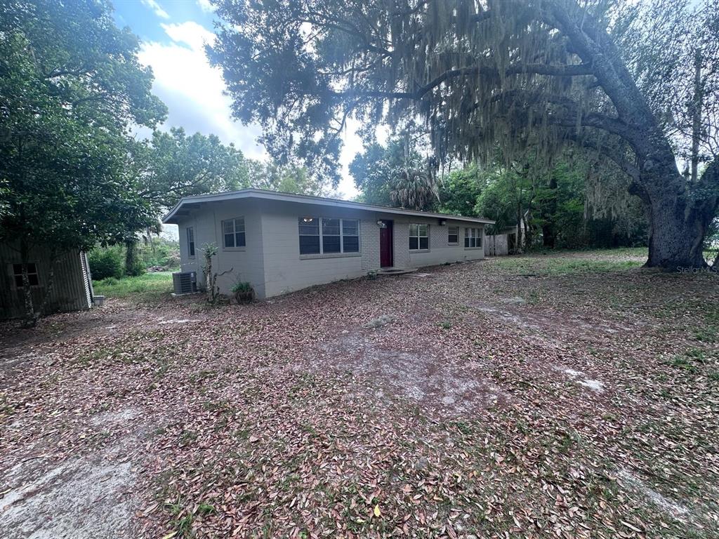 A single-story house with a beige exterior and a red front door sits on a lot — 3412 ORANOLE ROAD, ORLANDO, FL