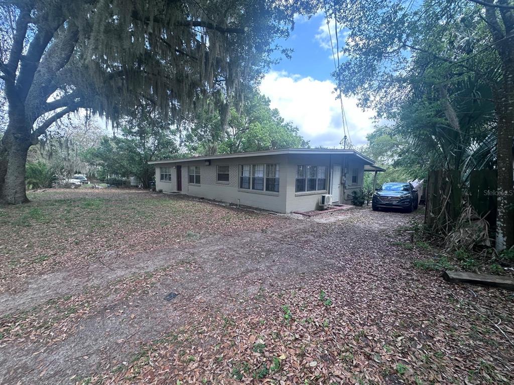 A single-story house with a beige exterior sits on a lot with trees and leaves — 3412 ORANOLE ROAD, ORLANDO, FL