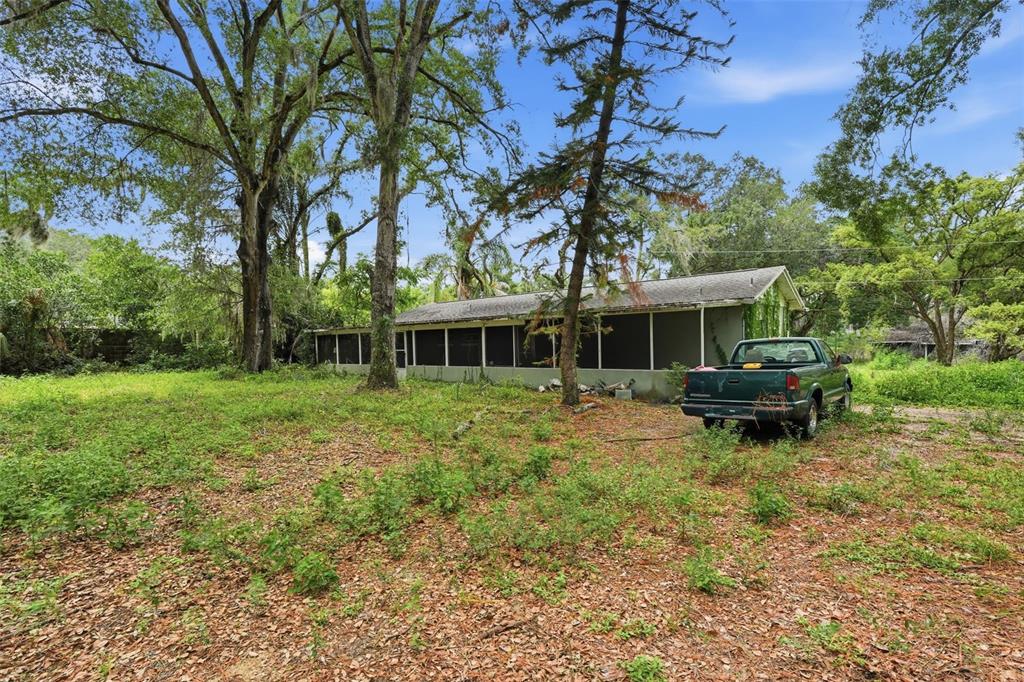 A green pickup truck is parked in front of a house with a screened-in porch — 832 S PARSONS AVENUE, BRANDON, FL