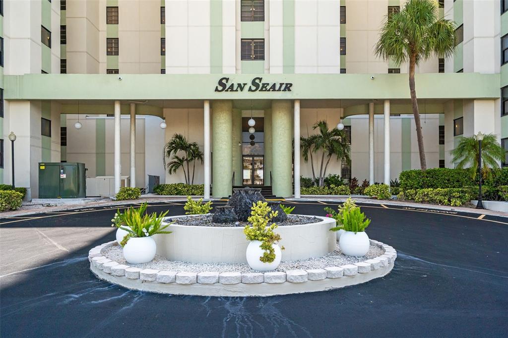 The exterior entrance of the San Seair building features a circular driveway and a fountain — 3820 GULF BOULEVARD UNIT 1205, ST PETE BEACH, FL