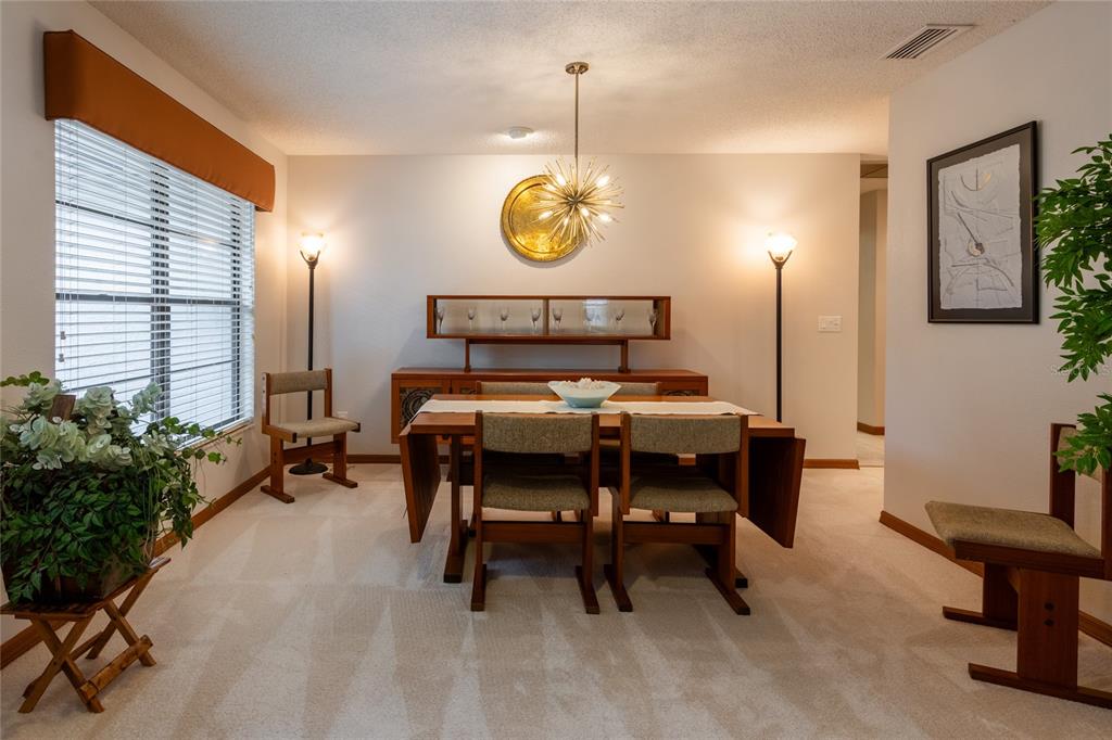 A dining room features a wooden table and chairs, a sideboard, and a sputnik chandelier — 16509 E COURSE DRIVE, TAMPA, FL