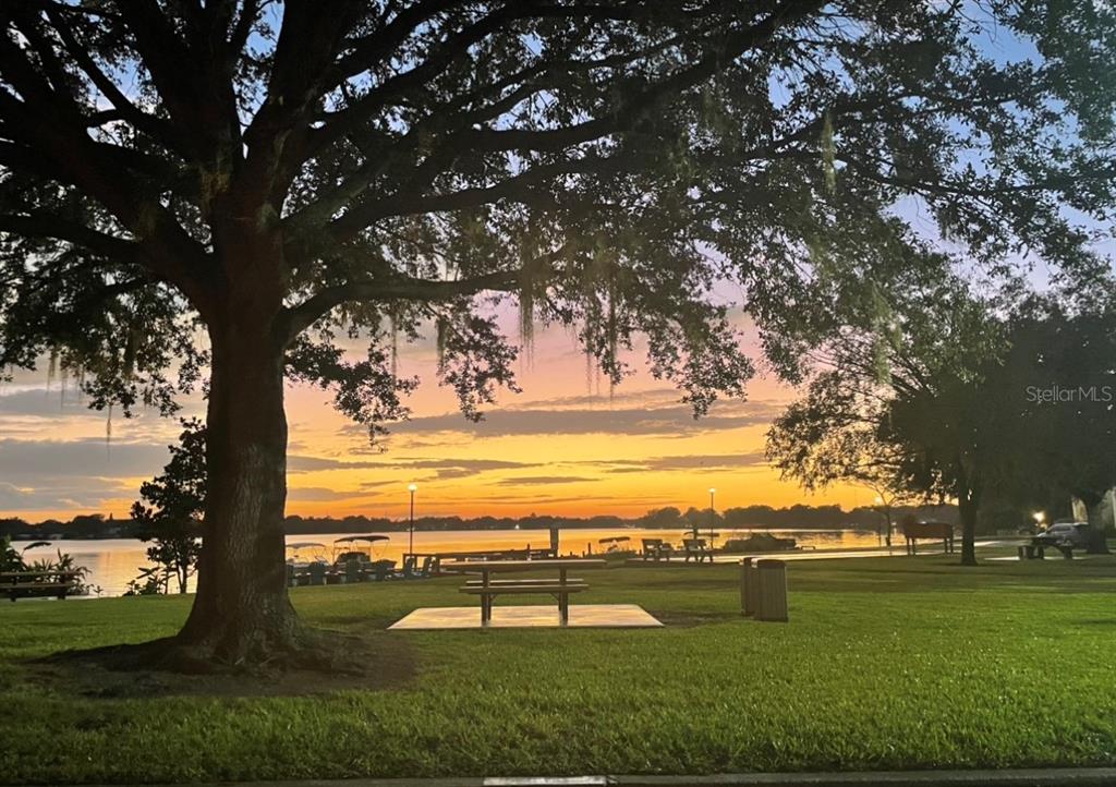 A park with a picnic table under a large tree overlooking a lake at sunset — 151 N ORLANDO AVENUE UNIT 242, WINTER PARK, FL