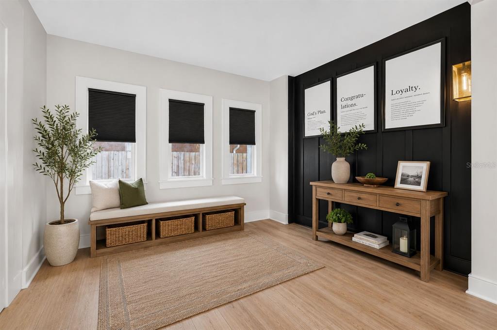 A two-story white stucco house features a covered front porch with a hanging swing — 6566 1ST AVENUE S, ST PETERSBURG, FL