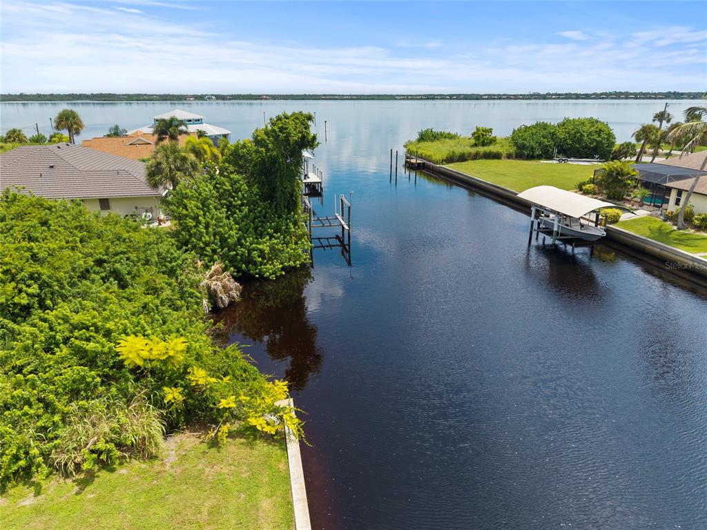 An aerial view shows a canal leading to a large body of water with docks — 2434 HERRON TERRACE, PORT CHARLOTTE, FL