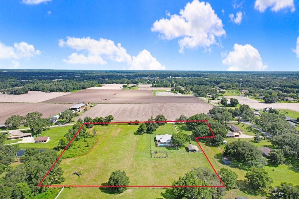 An aerial view shows a house with a pool on a large, fenced grassy lot — 13221 TOM GALLAGHER ROAD, DOVER, FL