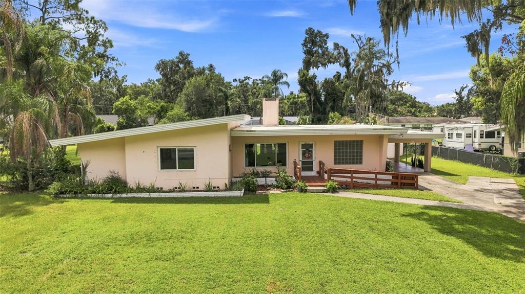 A single-story house with a slanted roof, a chimney, and a wooden ramp entrance — 1311 E TOMLIN STREET, PLANT CITY, FL