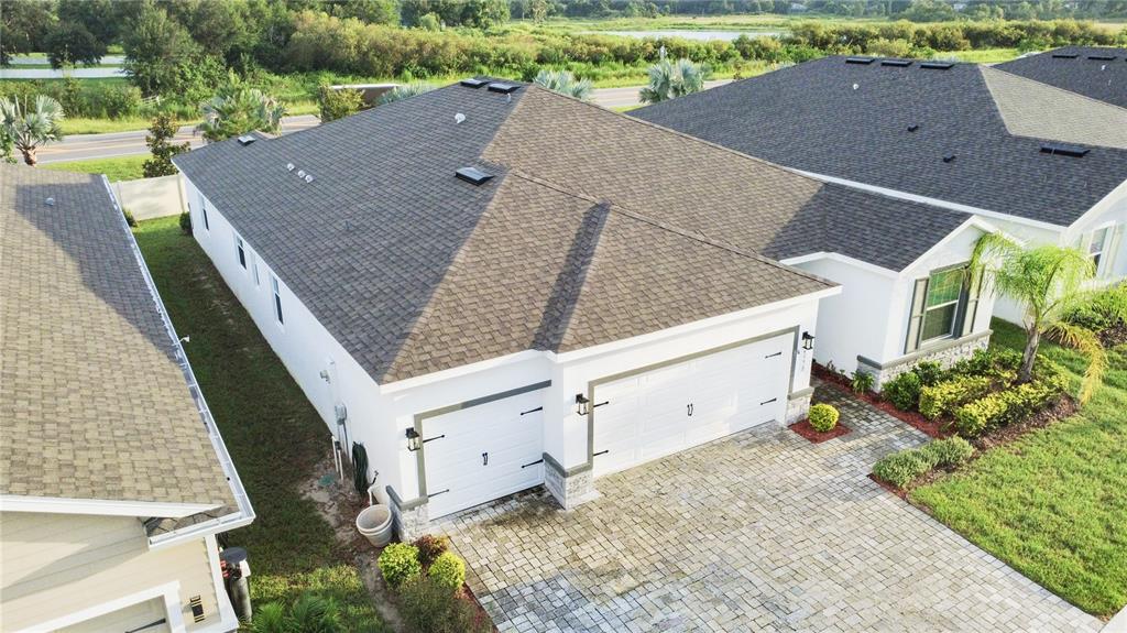 The exterior of a white stucco house features a screened-in porch and an air conditioning unit — 23278 SCAGLIONE DRIVE, LUTZ, FL