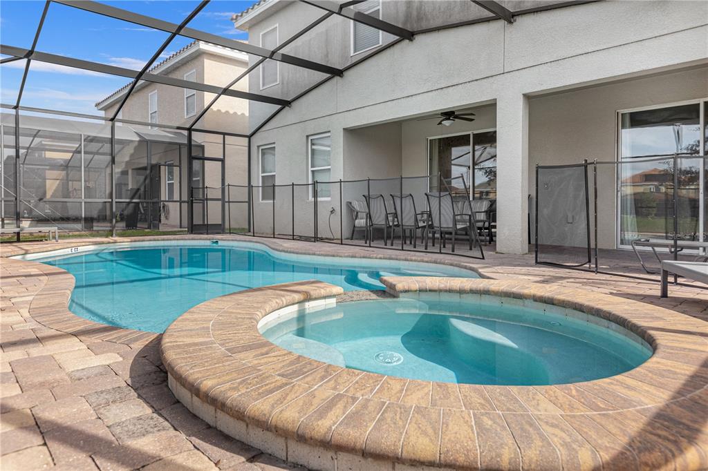 A backyard swimming pool and hot tub are enclosed by a screened lanai — 2580 SHANTI DRIVE, KISSIMMEE, FL