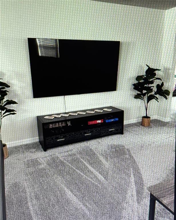 A wall-mounted television sits above a black media console in a carpeted living room — 7239 OAKMOSS LOOP, DAVENPORT, FL