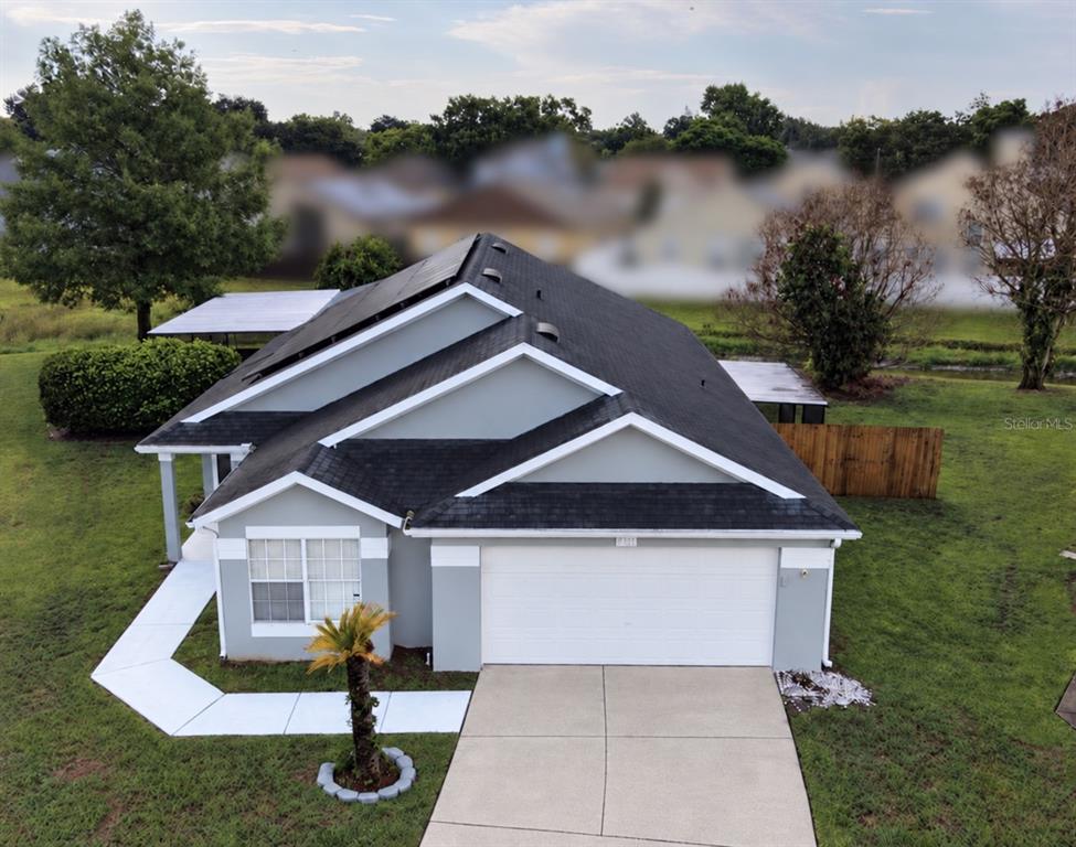 A single-story gray house with a two-car garage and a concrete driveway at dusk — 4702 FORT BRAVO COURT, ORLANDO, FL