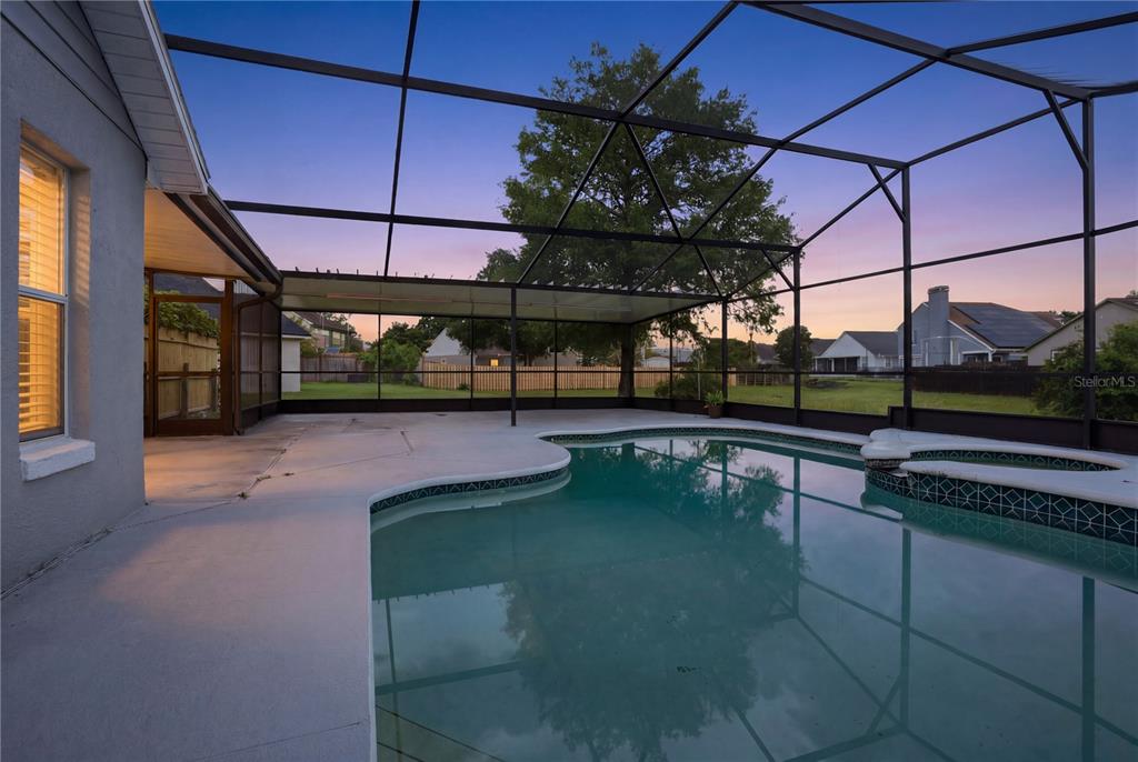 An aerial view of a house with solar panels, a screened-in pool, and a backyard — 4702 FORT BRAVO COURT, ORLANDO, FL