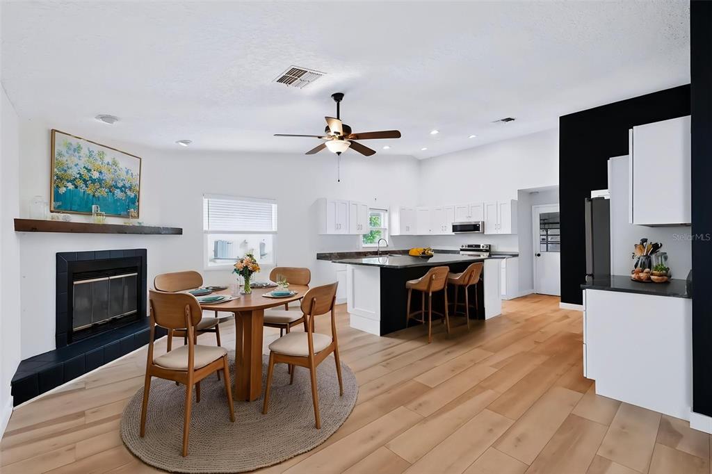 A kitchen features white cabinets, a large island with bar stools, and a blue accent wall — 1035 ANCLOTE DRIVE, TARPON SPRINGS, FL