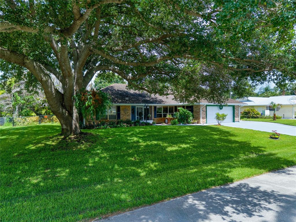 A single-story brick house with a large oak tree in the front yard — 465 11TH AVENUE, VERO BEACH, FL